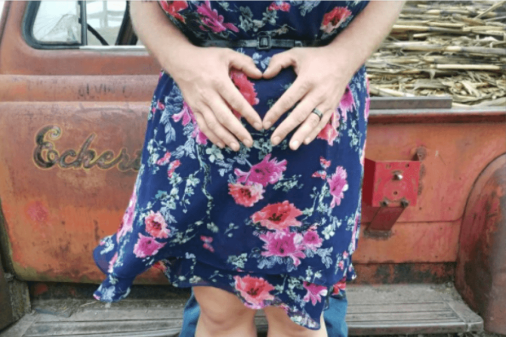 pregnant belly with hands as a heart