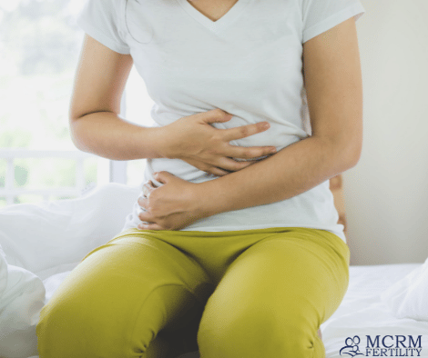 woman holding stomach suffering from cramps or constipation
